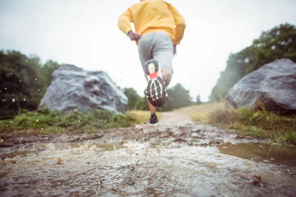 Ma jogging through muddy puddles — Stock Photo, Image