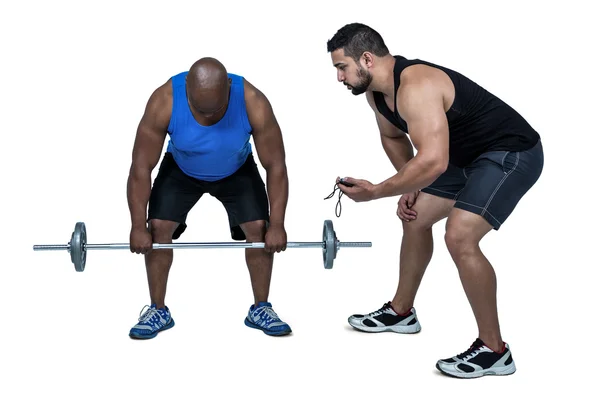 Hombre levantando barra con entrenador — Foto de Stock