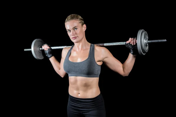 Muskulöse Frau, die schwere Langhantel hebt — Stockfoto
