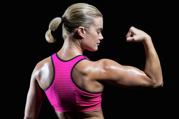 Mulher muscular flexionando o braço — Fotografia de Stock