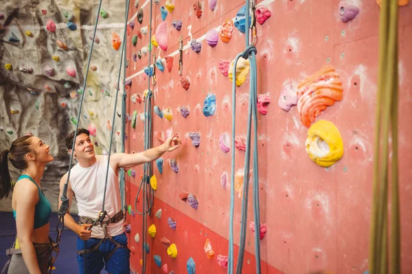 Instructor showing  rock climbing wall