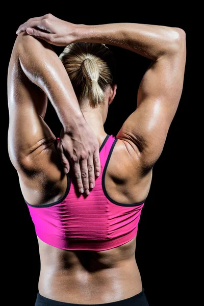 Muskulös kvinna stretching hennes armar — Stockfoto