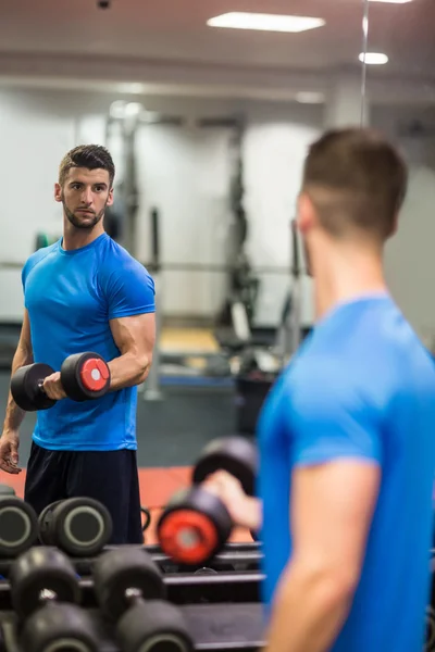 Hombre usando pesas en su entrenamiento — Foto de Stock