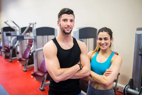 Vrouw en trainer door de gewichten machines — Stockfoto