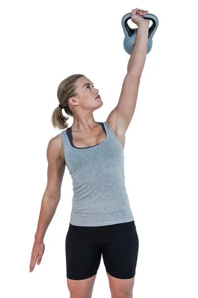 Femme musculaire sérieuse soulevant kettlebell — Photo