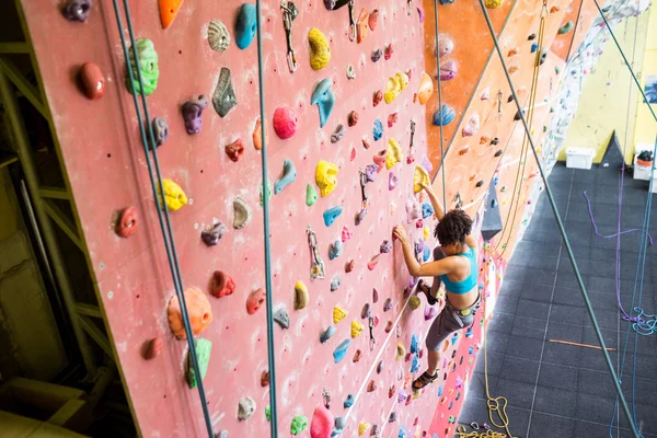 Adatto donna arrampicata su roccia al chiuso — Foto Stock