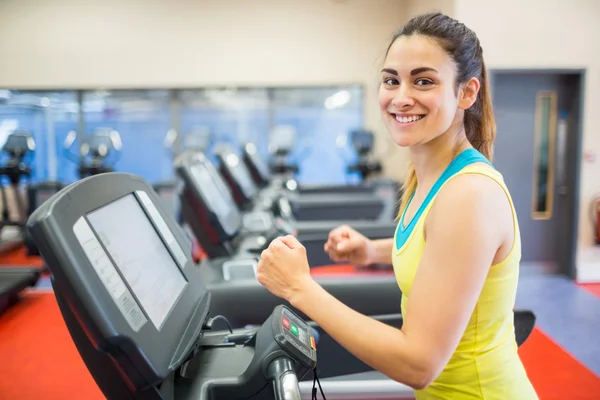 Lächelnde Frau läuft auf einem Laufband — Stockfoto