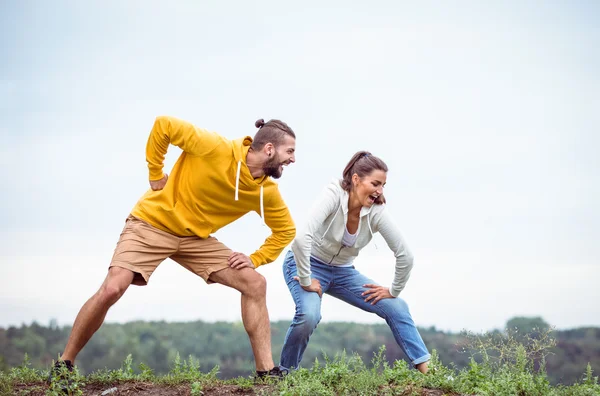 Paar streckt sich auf einer Wanderung — Stockfoto