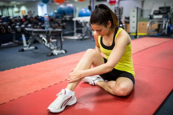 Mujer masajeando su pierna lesionada — Foto de Stock