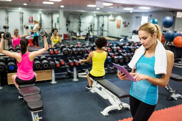 Ajuste mujer usando tableta en sala de pesas — Foto de Stock