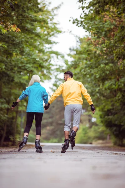 Gelukkige paar roller blading samen — Stockfoto