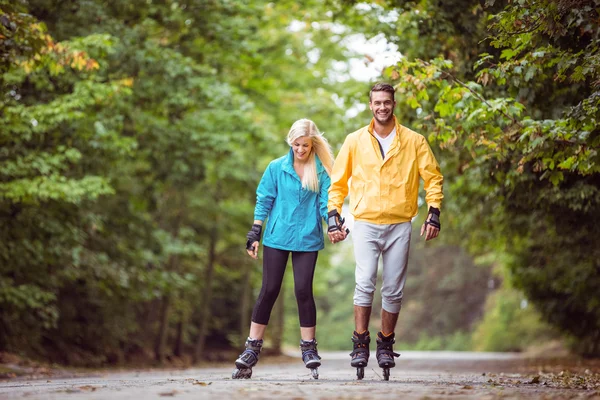 Happy couple roller blading together — Stock Photo, Image