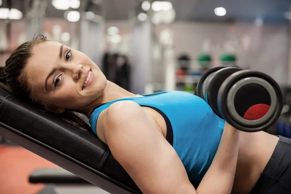 Mujer sonriente levantando mancuerna — Foto de Stock