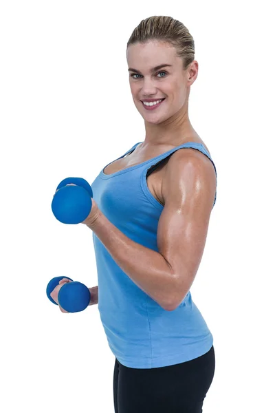 Мускулистая женщина тренируется с гантелями — стоковое фото