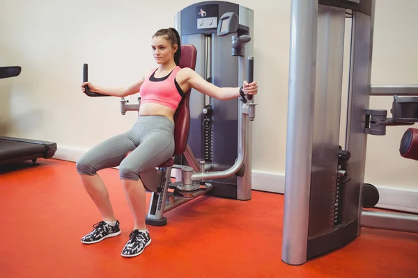 Femme utilisant la machine de poids pour les bras — Photo