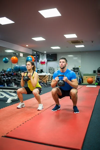 Casal segurando kettlebell — Fotografia de Stock