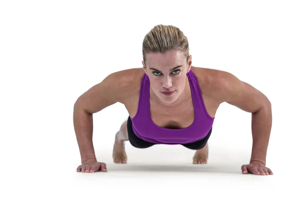 Muscular woman doing push ups — Stock Photo, Image