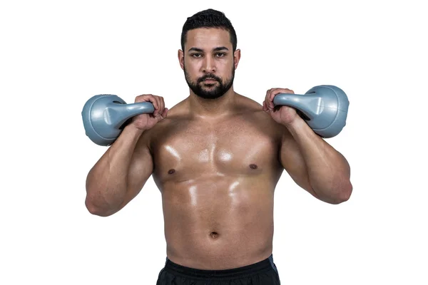Muskularny mężczyzna podnoszenia ciężkich kettlebells — Zdjęcie stockowe