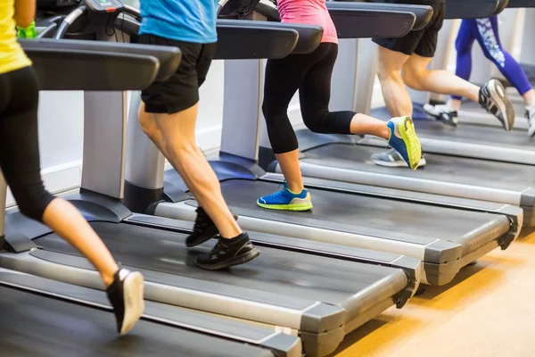 Ajustar a la gente corriendo en las cintas de correr — Foto de Stock