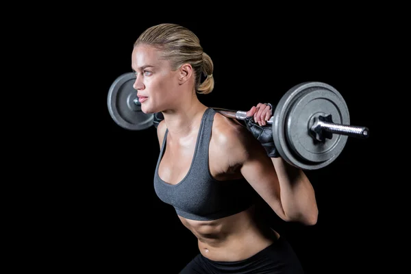 Vrouw hijs zware barbell — Stockfoto