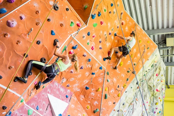 Fit couple rock climbing indoors — Stock Photo, Image