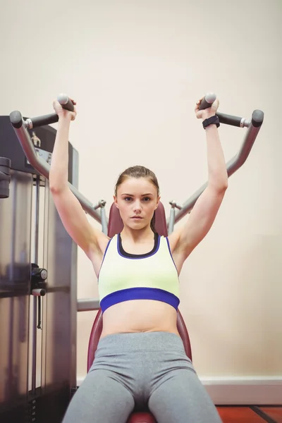 Frau benutzt Gewichtmaschine für Arme — Stockfoto