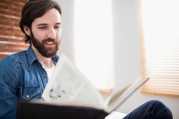 Casual man läser på hans soffa — Stockfoto