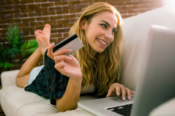 Pretty blonde relaxing on the couch using laptop — Stock Photo, Image