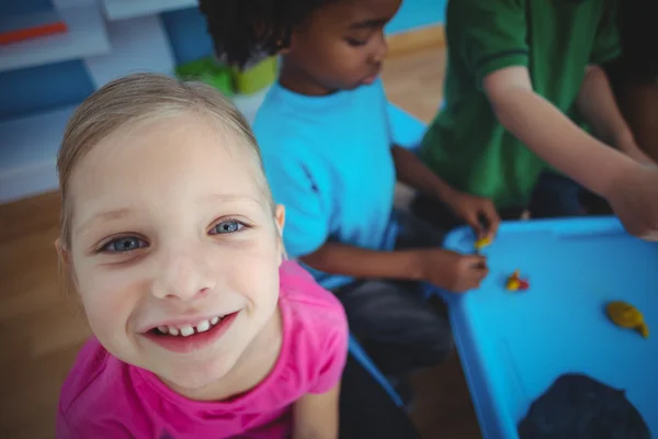 Smiling kids playing with modelling clay — Stock Photo, Image