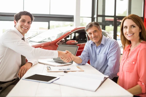 Customers signing documents at car showroom — Stock Photo, Image