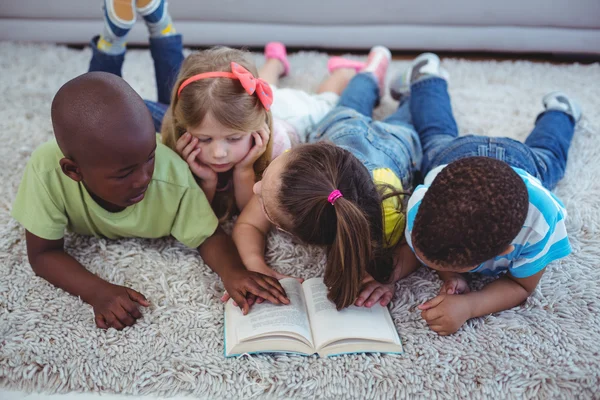 Crianças felizes lendo um livro juntas — Fotografia de Stock