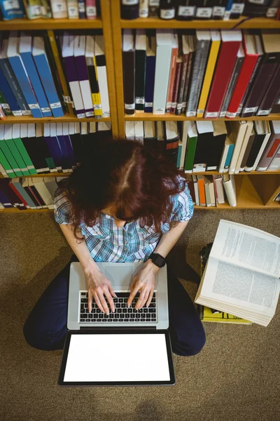 Зріла студентка в бібліотеці за допомогою ноутбука — стокове фото
