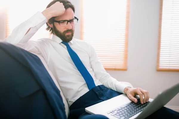 Empresario usando portátil en el sofá — Foto de Stock