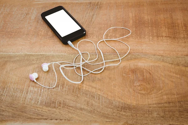 Black smartphone with white headphones — Stock Photo, Image