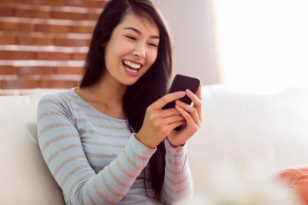 Asiatisk kvinna läser texten på soffan — Stockfoto