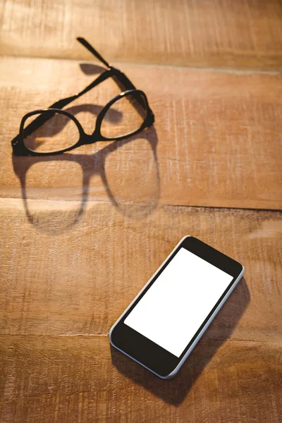 Smartphone y gafas en tablón de madera — Foto de Stock