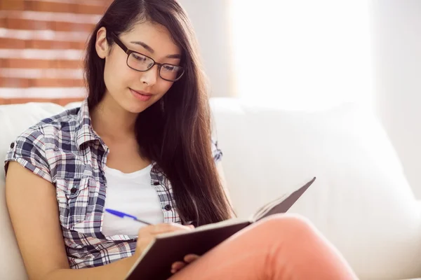 Asiatico donna su il divano scrittura — Foto Stock