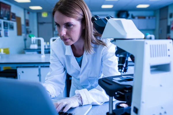 Scientifique travaillant avec un ordinateur portable en laboratoire — Photo