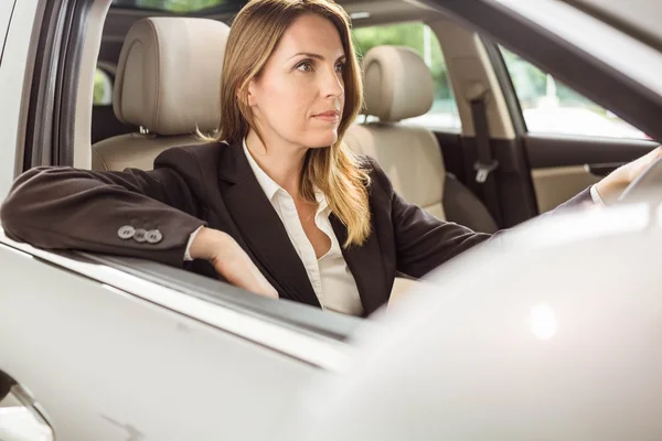 Leende affärskvinna lokalisering i en bil — Stockfoto