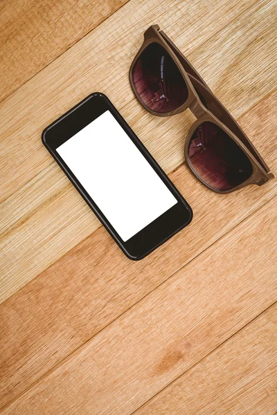 Brille und Smartphone auf Holztisch — Stockfoto