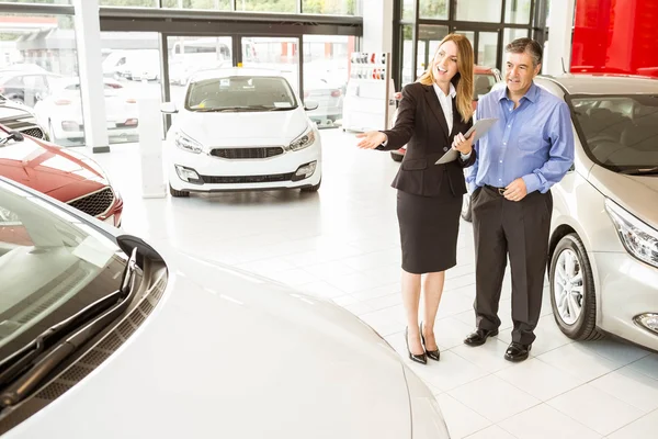 Empresária sorridente mostrando carro ao cliente — Fotografia de Stock