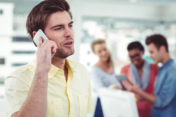 Kreativer Geschäftsmann nutzt Smartphone vor Kollegen — Stockfoto