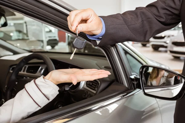 Vendeur offrant la clé de voiture aux clients — Photo