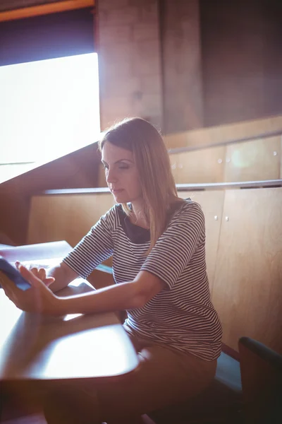 Reife Studentin mit Tablet im Hörsaal — Stockfoto