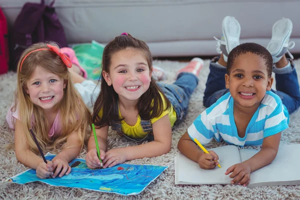 Niños sonrientes dibujando imágenes en papel — Foto de Stock