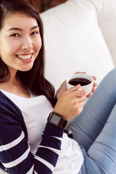 Donna asiatica rilassante sul divano con caffè — Foto Stock