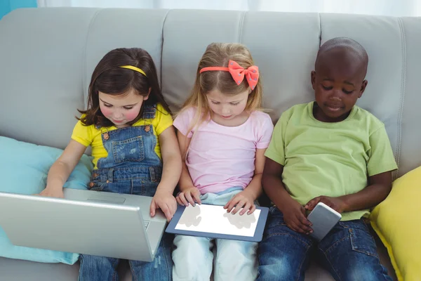 Bambini felici seduti insieme con una tavoletta — Foto Stock