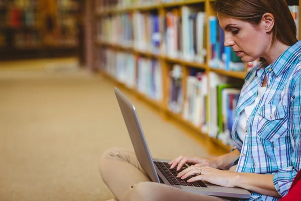Mogen student i biblioteket med laptop — Stockfoto