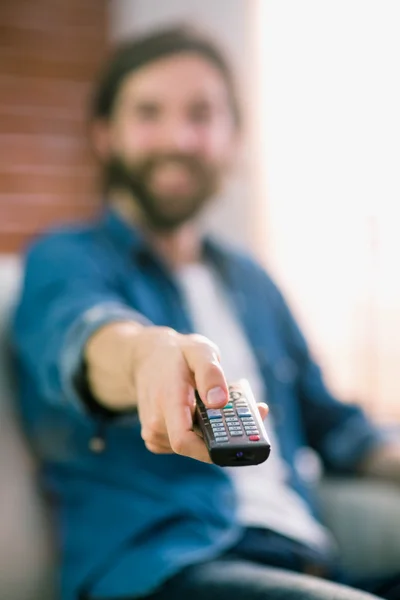 Casual man tv kijken op zijn bank — Stockfoto