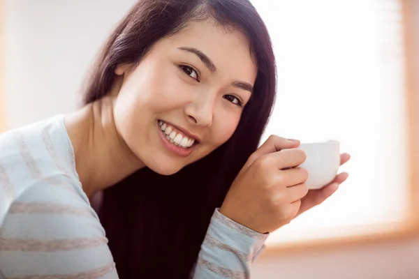 Donna asiatica rilassante sul divano con caffè — Foto Stock